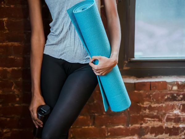 Neatly rolled yoga mat, a water bottle, and comfortable sportswear.